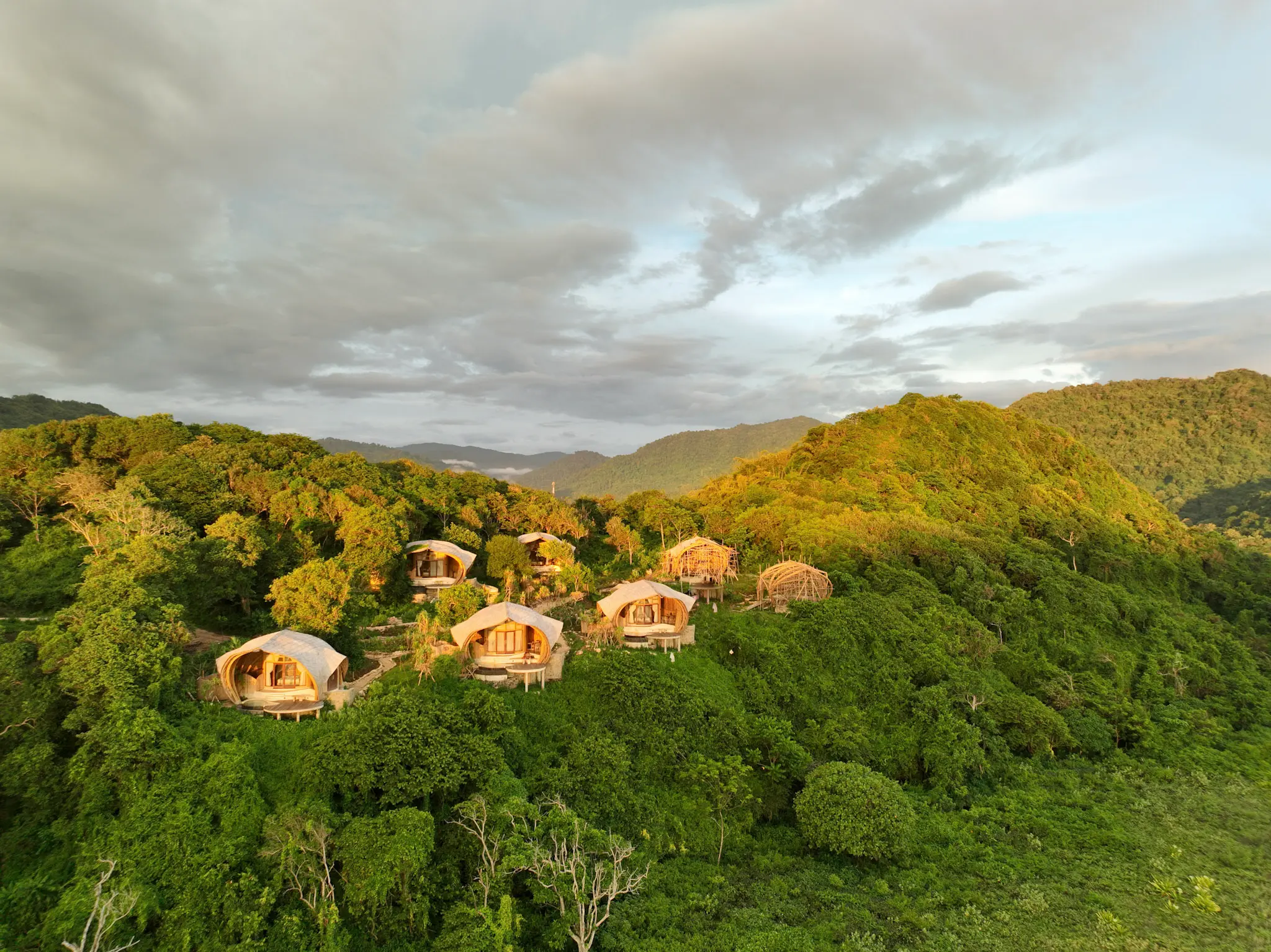 Aerial view of Kini Resort Beach View lodges surrounded by tropical jungle above the Indian Ocean, Sumbawa
