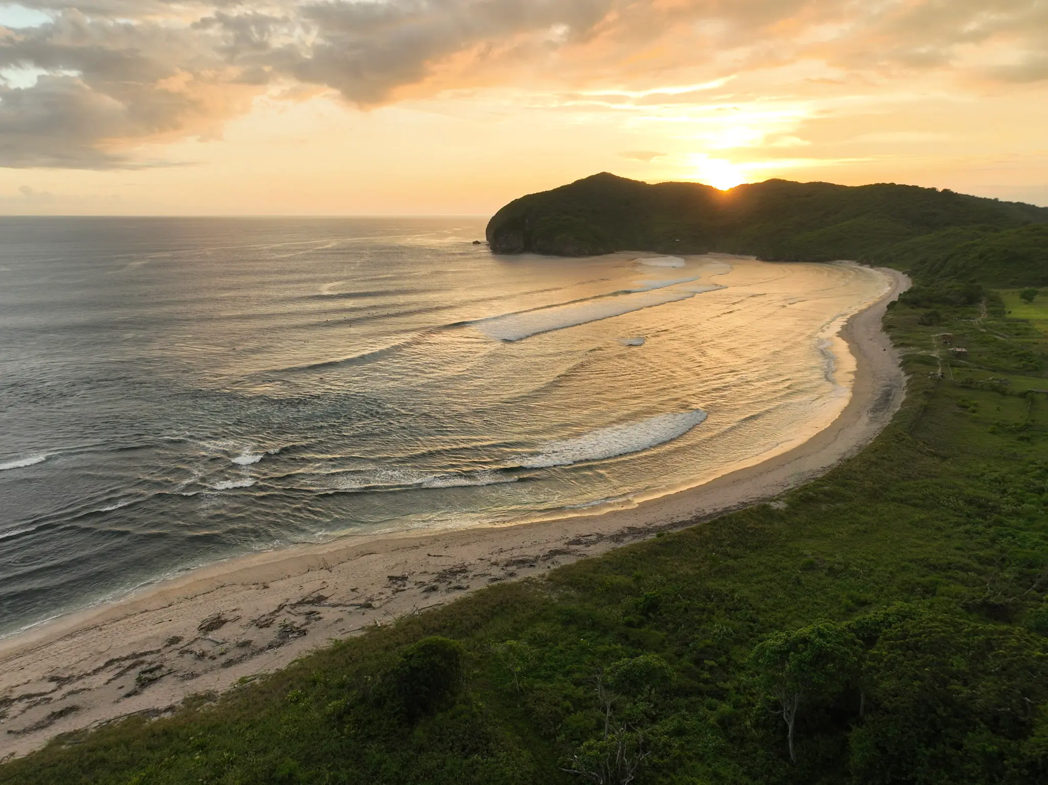 Drone view of Beach View lodge nestled into hillside jungle above the Indian Ocean — Kini Resort Sumbawa