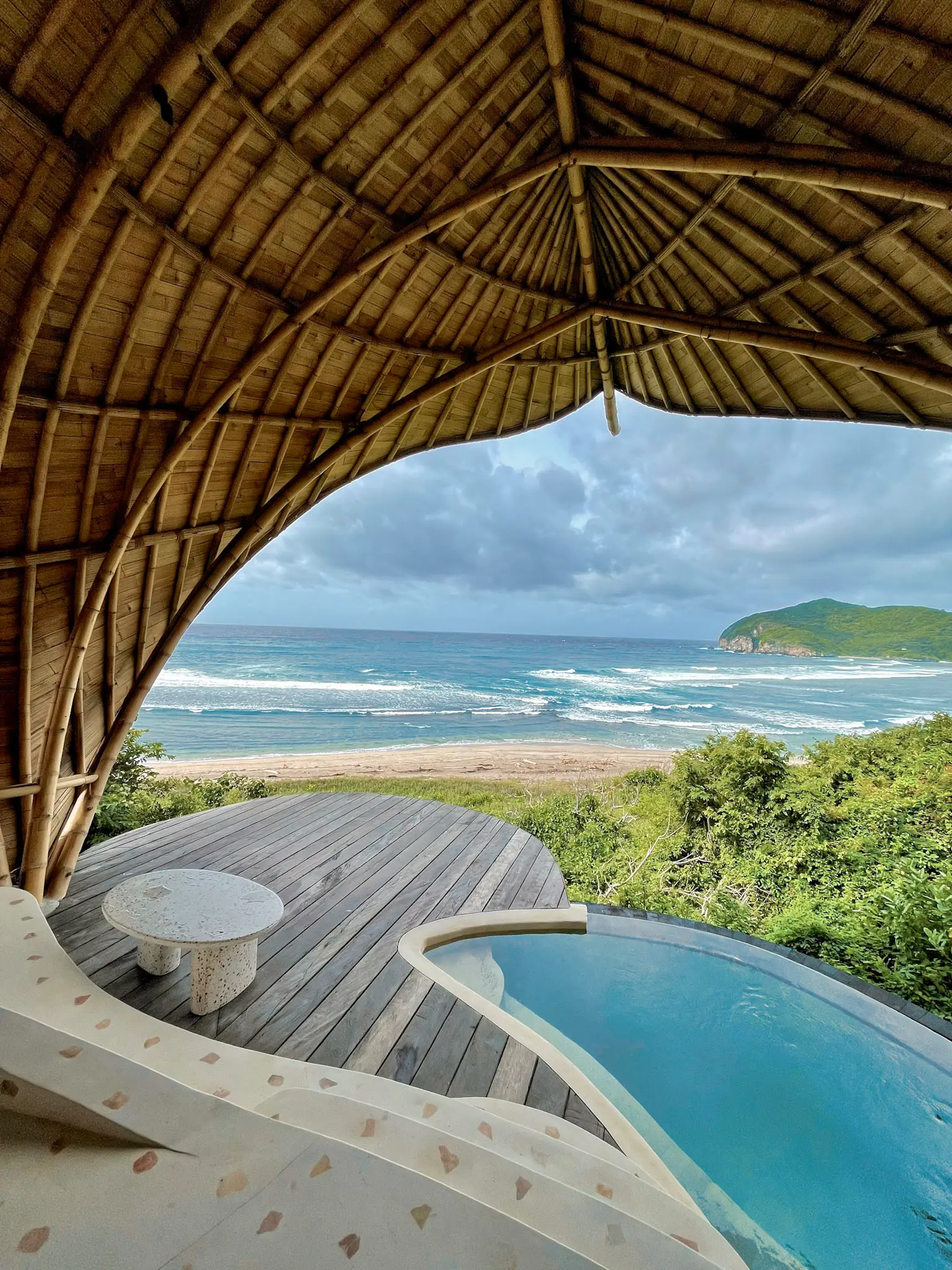 Guest relaxing at Eco Bamboo Beach View lodge pool overlooking the ocean — Kini Resort Sumbawa